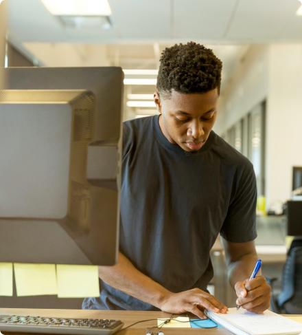 Person working at computer writing on tablet